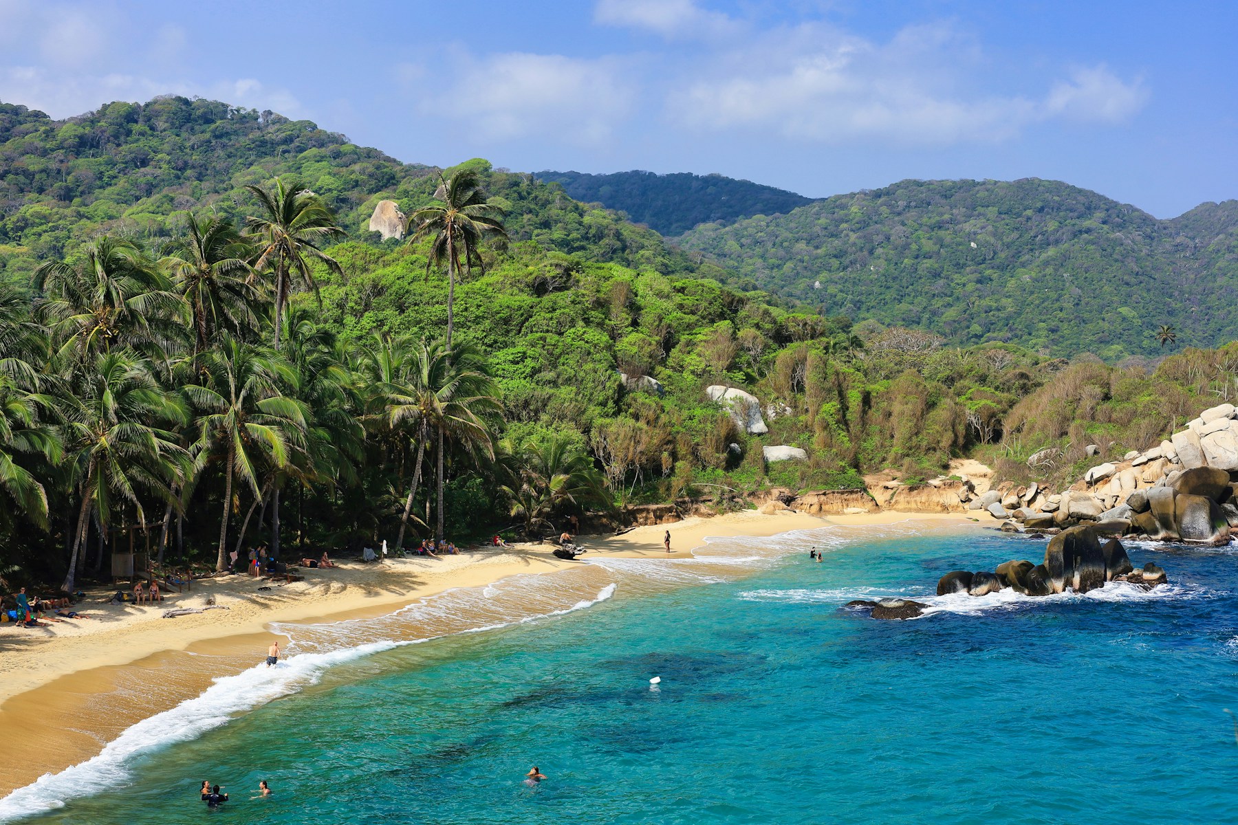 Playa rodeada de palmeras y montañas en el Parque Tayrona, Colombia